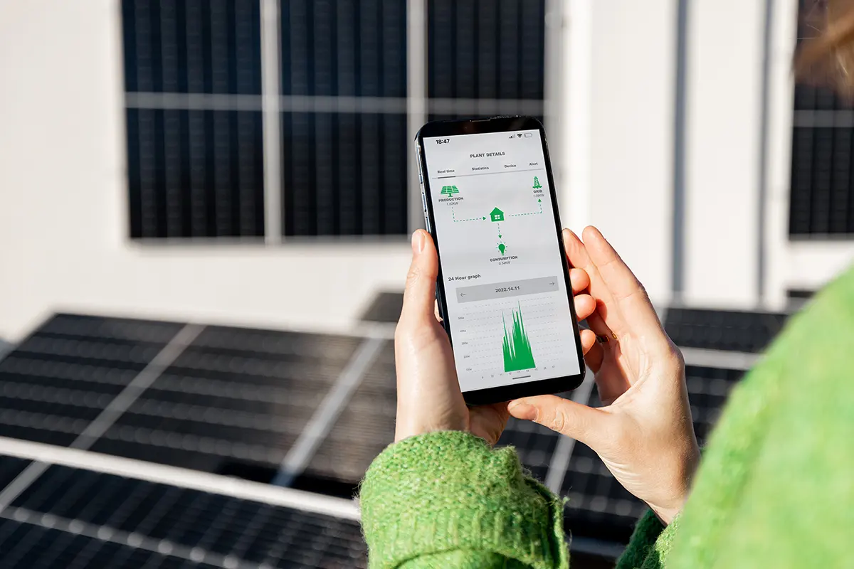 emhe - Frau überwacht Solarstrom mit Handy Frau überwacht Solarstrom mit Handy